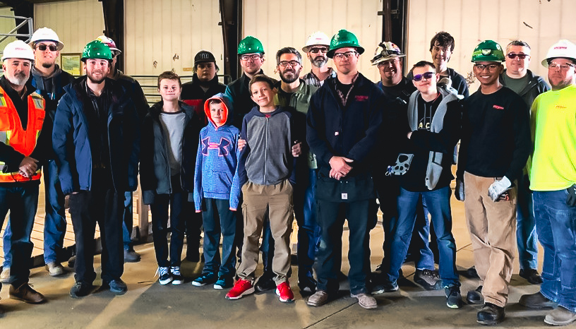 A group of Sturgeon Electric workers and autistic students.