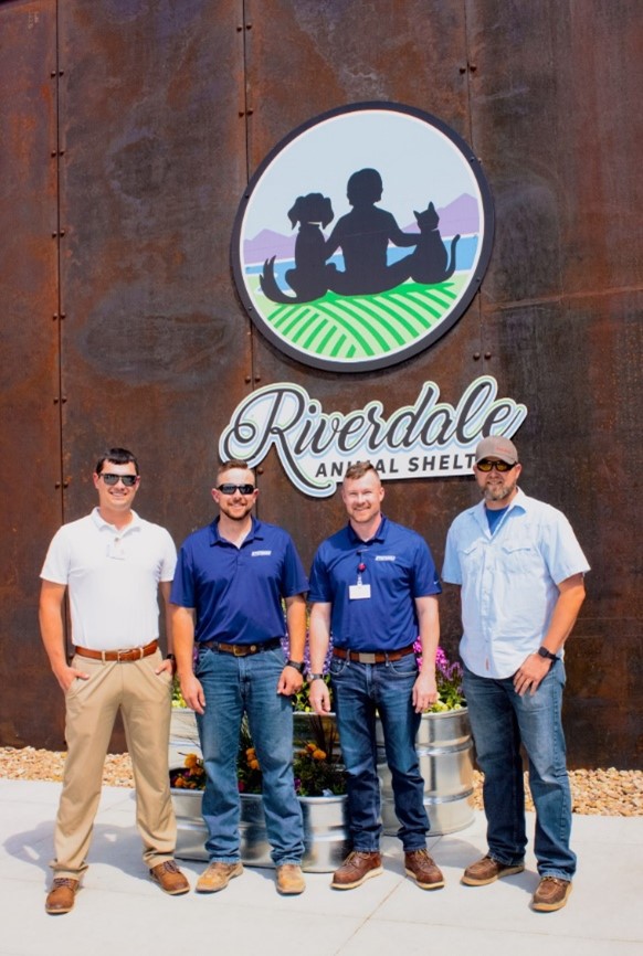 Four men stand in front of Riverdale Animal Shelter.